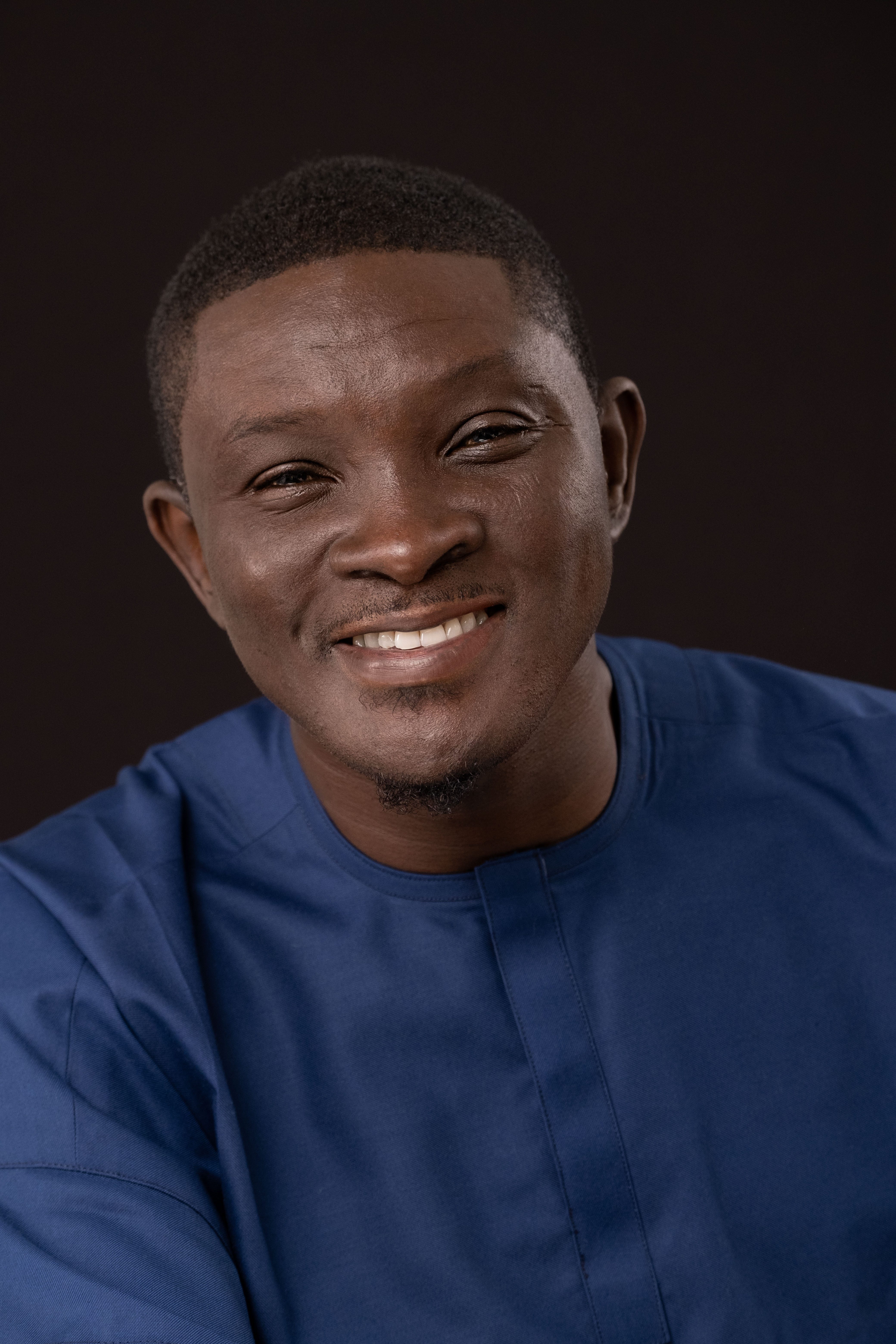 Paul Ugbede, Nigerian playwright and author, wearing a blue traditional outfit